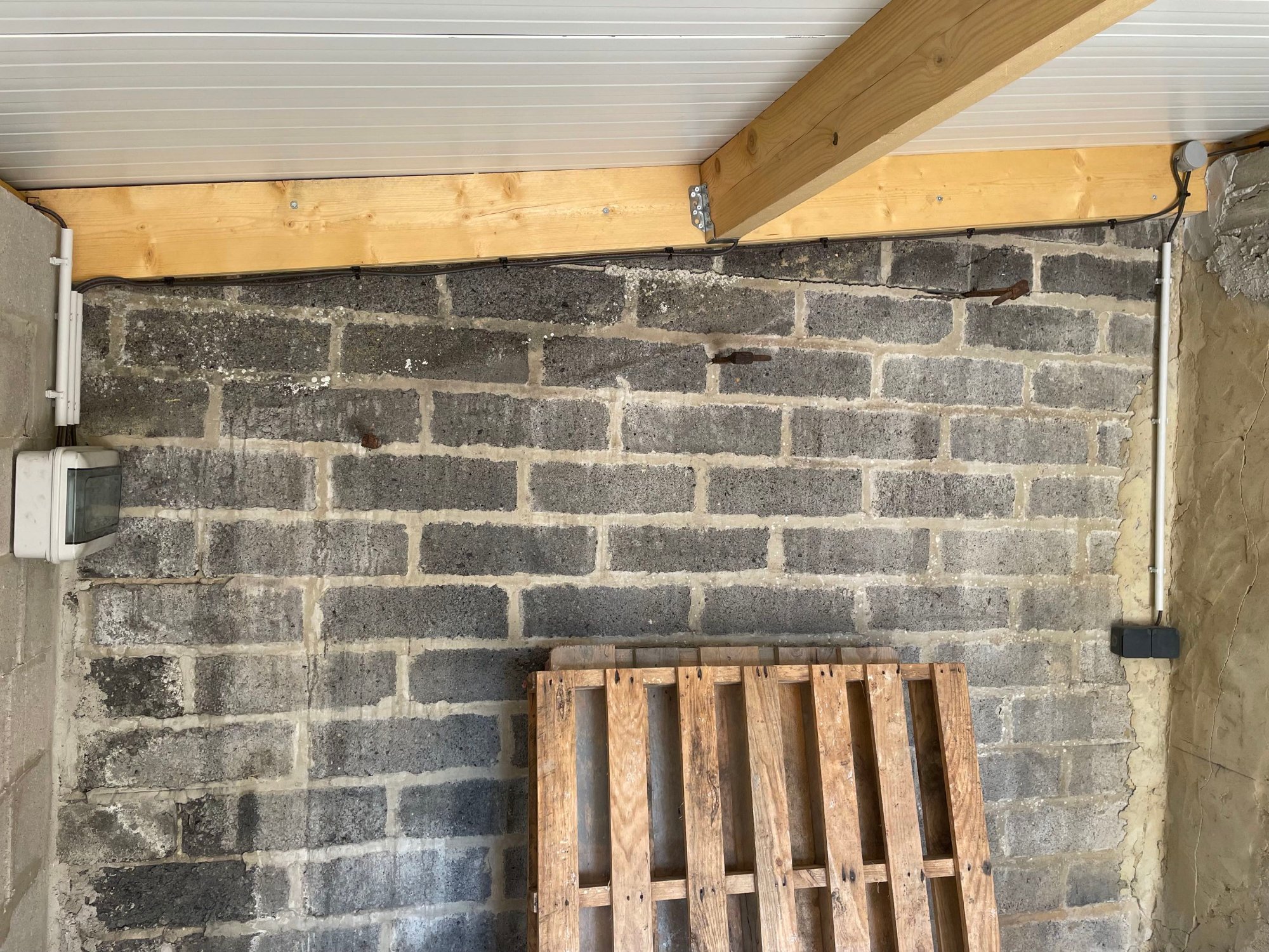 Interrupteur posé sur montant bois en entrée de garage – câble gainé sous goulotte blanche