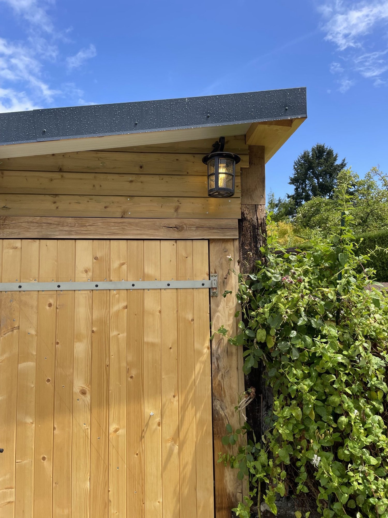 Applique lanterne extérieure posée en haut de façade bois du garage – éclairage d'entrée